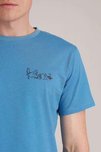 Mann in fairem Shirt in Blau mit Dog Band-Motiv