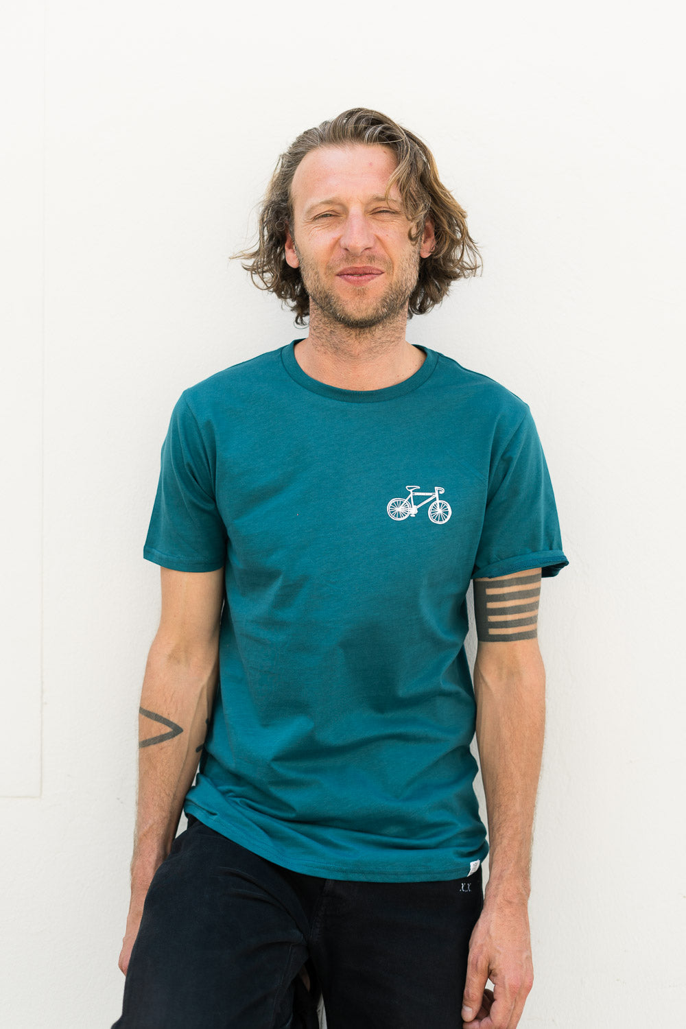 Mann mit nachhaltigen grünen Baumwoll shirt mit Fahrradmotiv drinnen