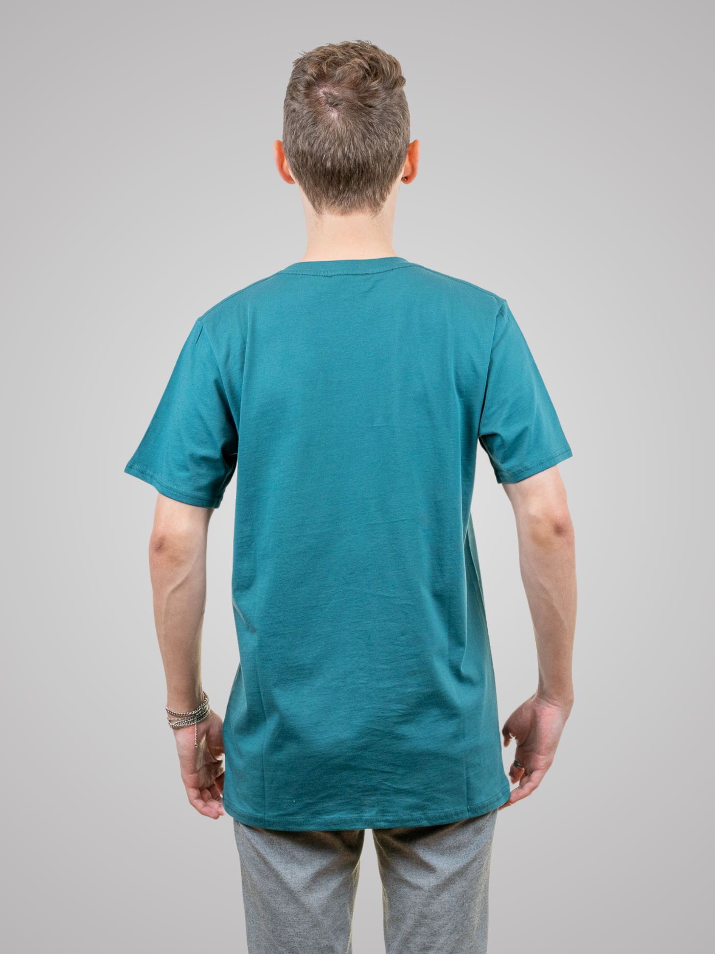 Mann mit nachhaltigen grünen Tshirt mit Bergmotiv  drinnen von hinten